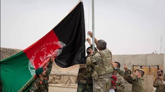 An Afghan flag is raised during a handover ceremony from the US Army to the Afghan National Army, at Camp Anthonic, in Helmand province, southern Afghanistan in May. (AP)