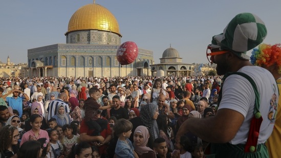 A clown entertains children on the first day of Eid al-Adha next to the Dome of the Rock Mosque in the Al Aqsa Mosque compound in Jerusalem's old city on Tuesday.(AP Photo/Mahmoud Illean)