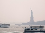 The Statue of Liberty sits behind a cloud of haze in New York City on July 20. According to data from the National Oceanic and Atmospheric Administration, wildfire smoke from the west has arrived in the tri-state area creating decreased visibility and a yellowish haze in many areas.(Spencer Platt / AFP)