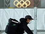 An Uber Eats delivery person carries items near the Japan National Stadium, where opening ceremony and other events are planned for postponed Tokyo 2020 Olympics(AP) An Uber Eats delivery person carries items near the Japan National Stadium, where opening ceremony and other events are planned for postponed Tokyo 2020 Olympics(AP)