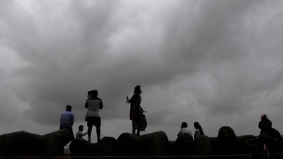 People sit by the sea shore in Mumbai. (AP) People sit by the sea shore in Mumbai. (AP)