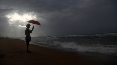 A man holds an umbrella as it rains on the beach by the Bay of Bengal coast in Visakhapatnam, Andhra Pradesh state, India, Thursday, July 15, 2021. (AP) A man holds an umbrella as it rains on the beach by the Bay of Bengal coast in Visakhapatnam, Andhra Pradesh state, India, Thursday, July 15, 2021. (AP)