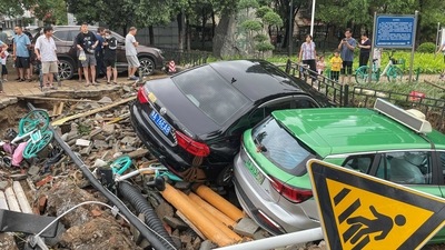 Damaged cars rest on debris after heavy rains hit the city of Zhengzhou causing floods in China's central Henan province on July 21, 2021. (Photo by STR / AFP) / China OUT (AFP) Damaged cars rest on debris after heavy rains hit the city of Zhengzhou causing floods in China's central Henan province on July 21, 2021. (Photo by STR / AFP) / China OUT (AFP)
