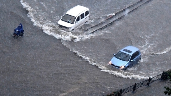 Vehicles pass through floodwaters in Zhengzhou. At least a dozen people died in severe flooding in a Chinese provincial capital that trapped people in subways and schools, washed away vehicles and stranded people in their workplaces overnight. (Zhu Xiang/Xinhua via AP)
