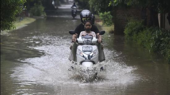 A motorist navigates a waterlogged stretch in Palam Vihar. (Vipin Kumar/HT PHOTO)