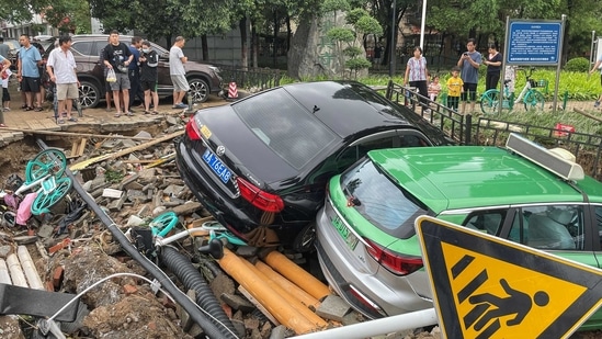 Damaged cars rest on debris after heavy rains hit the city of Zhengzhou causing floods in China's central Henan province on July 21, 2021. (Photo by STR / AFP) / China OUT(AFP)