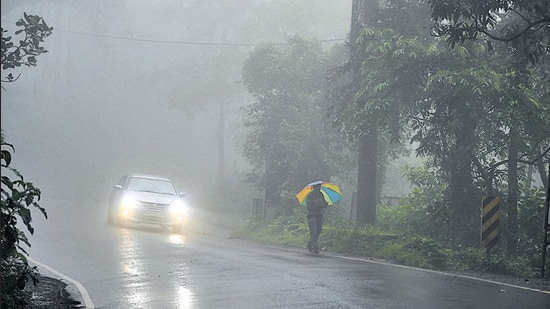 A commuter braves the rain and fog with his umbrella at Panchgani on Tuesday. (Kalpesh Nukte/HT PHOTO)