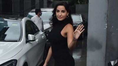 Nora Fatehi waves at the paparazzi. 