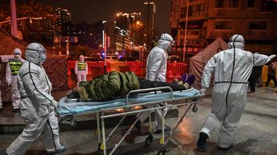 In this photo taken on January 25, 2020, medical staff wearing protective clothing to help stop the spread of a deadly virus which began in the city, arrive with a patient at the Wuhan Red Cross Hospital in Wuhan, China. (AFP)