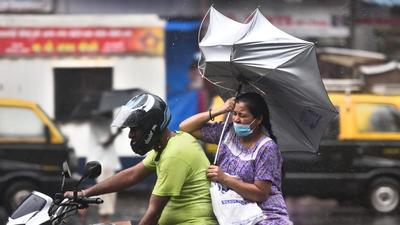 The umbrella of a woman riding pillion turns upside down amid heavy rain and gusty winds. (Satish Bate/HT PHOTO) The umbrella of a woman riding pillion turns upside down amid heavy rain and gusty winds. (Satish Bate/HT PHOTO)