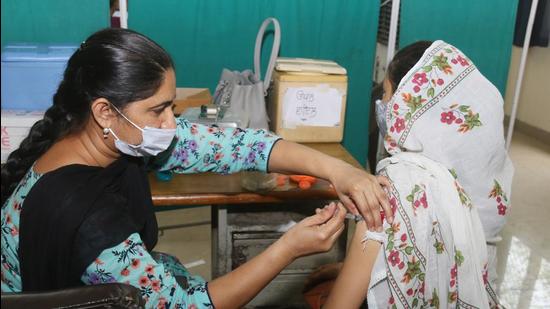 A medical worker inoculates a young woman with a dose of Covid-19 vaccine at  civil hospital vaccination centre in Bathinda, Punjab. (HT file photo)