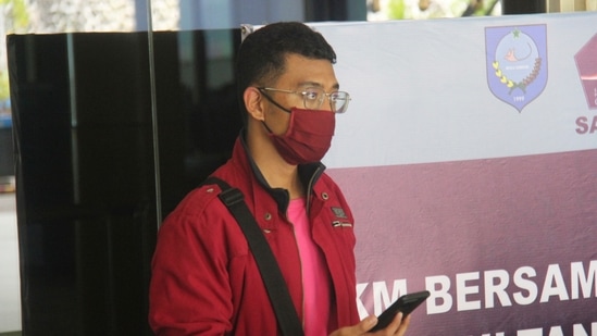 In this July 18 photo, a man who used a fake identity arrives at the Sultan Babullah airport in Ternate, Indonesia. The man with the coronavirus boarded a domestic flight disguised as his wife, wearing a niqab covering his face and carrying fake IDs and a negative PCR test result. He was arrested upon landing. (AP PHOTO)