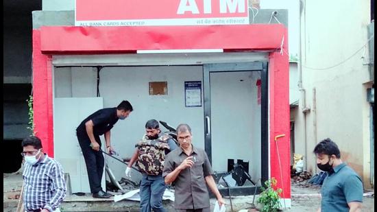 Police probe staff examine the spot for clues after robbers blow up an ATM near Chakan Vasuli phata road, on Wednesday. A group of men blow up an ATM centre in Pune using explosive and steal <span class='webrupee'>₹</span>28 lakh, according to the bank officials (HT)