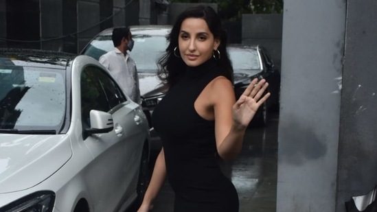 Nora Fatehi waves at the paparazzi.