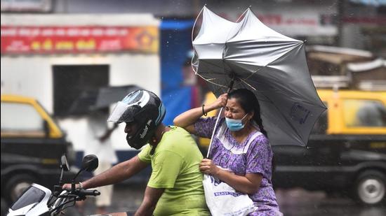 The umbrella of a woman riding pillion turns upside down amid heavy rain and gusty winds. (Satish Bate/HT PHOTO) The umbrella of a woman riding pillion turns upside down amid heavy rain and gusty winds. (Satish Bate/HT PHOTO)