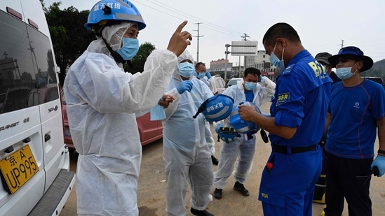 Rescuers in PPEs prepare for a searching operation in Gongyi city, near Zhengzhou, in central China's Henan province. (hoto by JADE GAO/AFP)