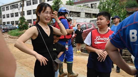 A woman and a boy cry to rescuers for help after being separated from their family members. (Photo by JADE GAO/AFP)