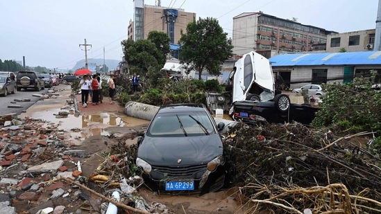 Damaged cars get stuck on a muddy road near Zhengzhou, in central China on July 22. (Photo by JADE GAO/AFP)