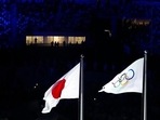 The flags of Japan and the Olympics wave during the opening ceremony in the Olympic Stadium at the 2020 Summer Olympics, Friday, July 23, 2021, in Tokyo, Japan.