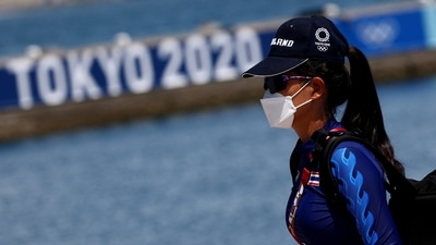 Tokyo 2020 Olympics - Sailing Training - Enoshima Yacht Harbor, Tokyo, Japan - July 23, 2021 A Thai athlete in a face mask walks past a Tokyo 2020 signage REUTERS/Carlos Barria (REUTERS)