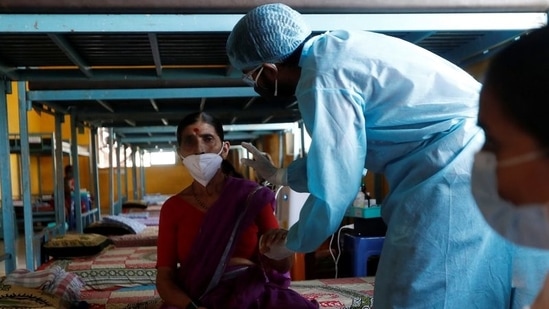 A doctor inspects a patient suffering from coronavirus disease (Covid-19) inside the classroom turned Covid-19 care facility on the outskirts of Mumbai, India, May 24, 2021. (REUTERS)