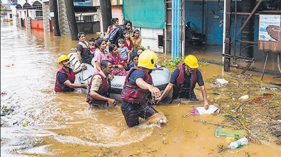 Municipal corporation firefighters during a rescue operation after heavy rain in Kolhapur, on July 22, 2021. Panchganga river flowing at warning level. (PTI)