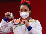 India's Mirabai Chanu Saikhom shows her silver medal that she won in the women's 49 kg weighlifting event.