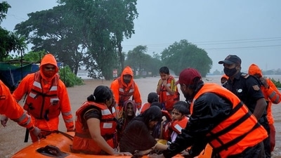 Rescue workers evacuate people from a flooded area to safer places after heavy rains in Kolhapur. (REUTERS) Rescue workers evacuate people from a flooded area to safer places after heavy rains in Kolhapur. (REUTERS)