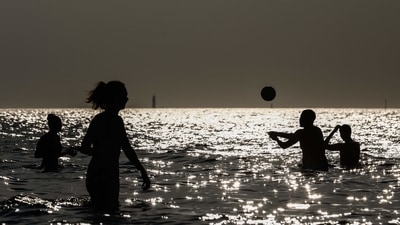 Tourists play volleyball in the water on a beach by the sea in Saint-Malo, western France. (AFP)