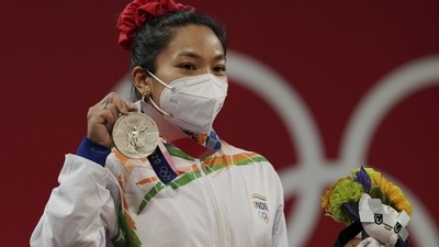 India's Mirabai Chanu wearing Olympic Rings ear-ring poses for photographs while standing on the podium after receiving the silver medal in women's 49 kg category weightlifting event at the Summer Olympics 2020, in Tokyo, Saturday, July 24, 2021. (PTI) India's Mirabai Chanu wearing Olympic Rings ear-ring poses for photographs while standing on the podium after receiving the silver medal in women's 49 kg category weightlifting event at the Summer Olympics 2020, in Tokyo, Saturday, July 24, 2021. (PTI)