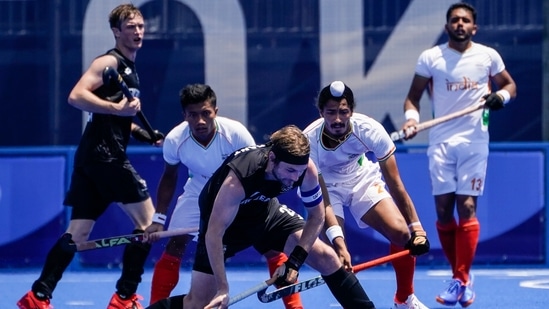 New Zealand's Blair Tarrant, center, looks to pass against India's Dilpreet Singh, center right, during a men's field hockey match at the 2020 Summer Olympics, Saturday, July 24, 2021, in Tokyo, Japan. (AP Photo/John Minchillo)(AP)