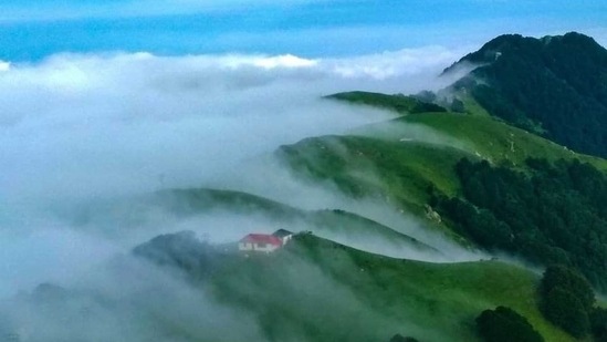 This image of a home nestled in a stunning lush green hills as clouds float serenely all around has been taken by Sidharth Maithani.(Sidharth Maithani)