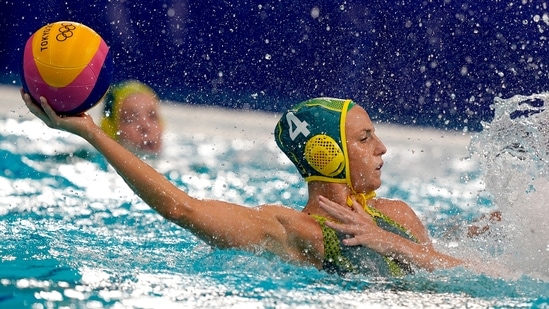 Australia's Bronte Halligan (4) protects the ball from a defender during a preliminary round women's water polo match against Canada at the 2020 Summer Olympics, Saturday, July 24, 2021, in Tokyo, Japan. (AP Photo/Mark Humphrey)(AP)
