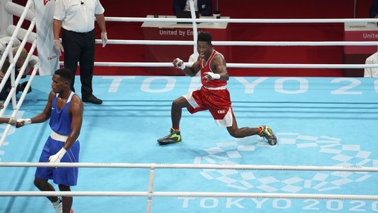 Cameroon's Albert Mengue Ayissi, center, celebrates during a men's welterweight 69-kg boxing match against Switzerland's Thabiso Dlamin, left, at the 2020 Summer Olympics, Saturday, July 24, 2021, in Tokyo, Japan. (AP Photo/David Goldman)(AP)