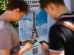 FILE - In this Wednesday, July 21, 2021 file photo, visitors register for Covid-19 tests at the Eiffel Tower in Paris. For Europe’s battered tourism industry, fresh virus outbreaks and chaos and confusion over travel rules are contributing to a another cruel summer. With Covid-19 variants surging in parts of Europe, popular destination countries are taking measures to contain outbreaks. In France, the world's most visited country, visitors to cultural and tourist sites were confronted Wednesday, July 21, 2021 with a new requirement for a special Covid-19 pass. To get it, people must prove they're either fully vaccinated or recently recovered from an infection, or produce a negative virus test.