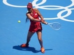 Naomi Osaka, of Japan, returns to China's Zheng Saisai during the tennis competition at the 2020 Summer Olympics.