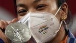 Tokyo Olympics 2020: India's Mirabai Chanu, wearing golden Olympic Rings ear-ring, poses for photographs while standing on the podium after receiving the silver medal in women's 49 kg category weightlifting event at the Summer Olympics 2020, in Tokyo.(PTI) Tokyo Olympics 2020: India's Mirabai Chanu, wearing golden Olympic Rings ear-ring, poses for photographs while standing on the podium after receiving the silver medal in women's 49 kg category weightlifting event at the Summer Olympics 2020, in Tokyo.(PTI)