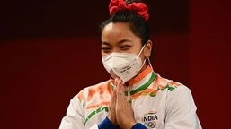 Silver medallist India's Mirabai Chanu gestures on the podium.