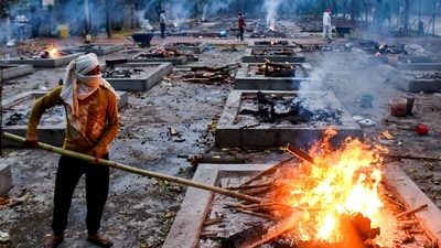 A worker stoking a funeral pyre during cremations of Covid-19 victims at Sarai Kale Khan crematorium, in New Delhi. A worker stoking a funeral pyre during cremations of Covid-19 victims at Sarai Kale Khan crematorium, in New Delhi.