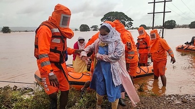 India's National Disaster Response Force (NDRF), shows NDRF personnel rescuing stranded villagers from flooded areas following heavy monsoon rains in Balinge village of Kolhapur district of Maharashtra. (AFP)