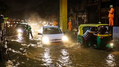 Commuters wade through a waterlogged street during rain at KR market in Bengaluru. (PTI) Commuters wade through a waterlogged street during rain at KR market in Bengaluru. (PTI)