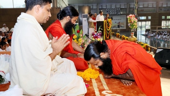 Seorang suci mencari berkah dari guru yoga Baba Ramdev pada malam Guru Purnima, di Haridwar. (ANI)