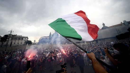 A protester holds an Italian flag as he takes part in a demonstration in Piazza del Popolo in Rome.(AFP) A protester holds an Italian flag as he takes part in a demonstration in Piazza del Popolo in Rome.(AFP)