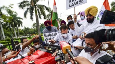 Congress leader Rahul Gandhi on a tractor outside the Parliament, in support of farmers' agitation against Centre's farm laws, in New Delhi on Monday, July 26. (PTI)