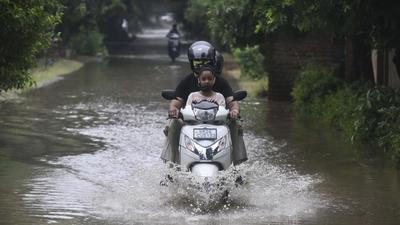 Gurugram, India-July 13: Commuters on a two-wheeler crossing a waterlogged stretch during rain, in Palam Vihar, Gurugram, India, on Tuesday, July 13, 2021. (Photo by Vipin Kumar/Hindustan Times) (Vipin Kumar/HT PHOTO) Gurugram, India-July 13: Commuters on a two-wheeler crossing a waterlogged stretch during rain, in Palam Vihar, Gurugram, India, on Tuesday, July 13, 2021. (Photo by Vipin Kumar/Hindustan Times) (Vipin Kumar/HT PHOTO)
