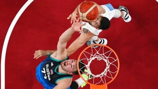 Slovenia's Luka Doncic (77) scores past Argentina's Patricio Garino (29) during a men's basketball preliminary round game at the 2020 Summer Olympics, Monday, July 26, 2021, in Saitama, Japan. (Aris Messinis/Pool Photo via AP)(AP)