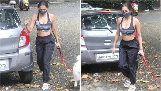 Malaika teamed her top with a pair of black joggers, white sliders, and a black face mask. She styled her street-style look by tying her locks in a loose ponytail, flaunting her natural glow and wearing a dainty gold chain.(Varinder Chawla)