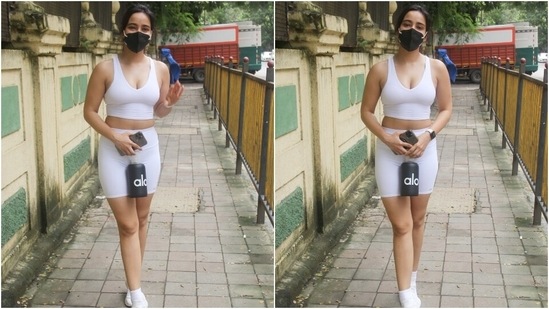 Neha Sharma chose an all-white look as she was snapped taking a stroll on the streets of Mumbai. She wore a white sleeveless V-neck sports bra with high-waist biker shorts, nailing a trend first made famous by Kim Kardashian.(Varinder Chawla)