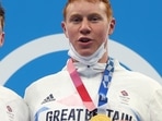 Tom Dean of Britain (right) and Duncan Scott (left) of Britain pose with their gold and silver medal that they won in the men's 200m freestyle swimming event at the Tokyo Olympics.