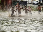 Children play on a waterlogged street after heavy rains near ITO in New Delhi.(PTI)